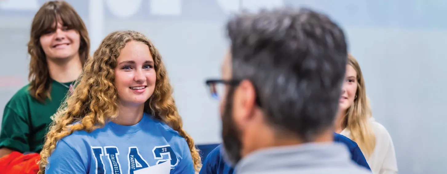 Student smiling during group activity indoors.